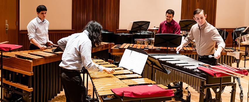 Students in the percussion ensemble playing their instruments.